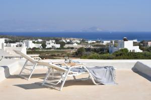 a white chair and table on a roof with a view at White Santa Maria Villa in Santa Maria