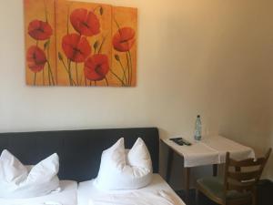 a room with a bed and a table and a painting at Hotel zum Taunus in Eppstein