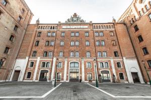 a large brick building with a clock on top at Molino Stucky Apartment Wi-Fi R&R in Venice