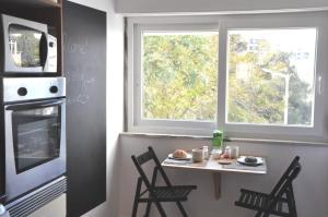 a kitchen with a table with chairs and a window at Cascais Family & Friends in Cascais