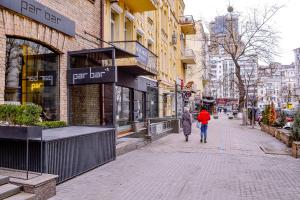 un par de personas caminando por una calle de la ciudad en CentrRoomKiev en Kiev