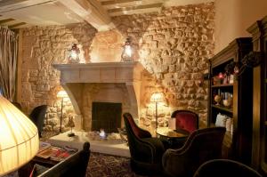 sala de estar con pared de piedra y chimenea en Hotel Odeon Saint-Germain, en París