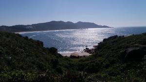 vistas al océano desde una colina con playa en Loft Barra da Lagoa, en Florianópolis