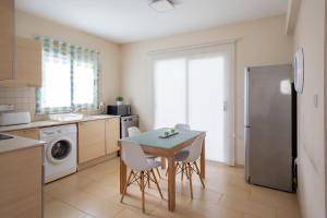 a kitchen with a table and chairs and a refrigerator at Athena Villa in Ayia Napa