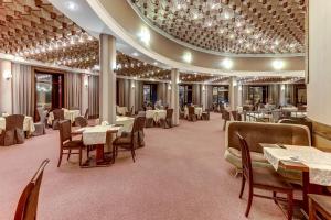 Tourist Hotel في أومسك: مطعم بطاولات وكراسي وسقف ثابت