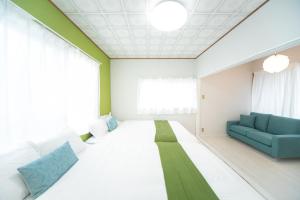 um quarto de hospital com uma cama e um sofá em Yokkaichi Higashihino Hotel em Yokkaichi