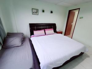 Sea & Wave #2 Coral Bay Apartment في بانكور: سرير عليه وسادتين ورديتين