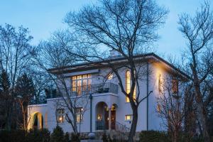 a large white house with its lights on at Bagatelle Gardenhouse in Budapest