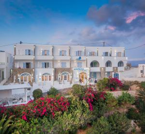 a large white building with flowers in front of it at Vardia Bay Studios in Karavostasi