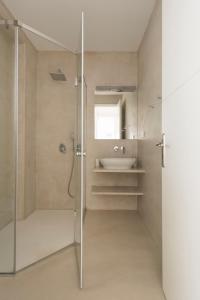 een badkamer met een douche en een wastafel bij White Santa Maria Villa in Santa Maria