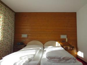 a bed with two white pillows in a room at Pension Churlis in Lech am Arlberg