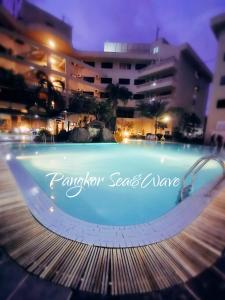 a swimming pool in front of a building at night at Sea & Wave #2 Coral Bay Apartment in Pangkor