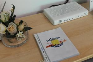 un livre assis sur un bureau à côté d'un ordinateur portable dans l'établissement Residence Sol Levante, à Frascati