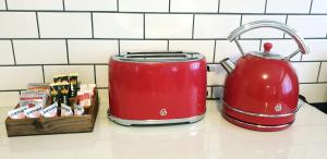 a red toaster and a tea pot on a counter at Summerville Place in Addo