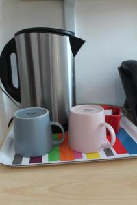 - deux tasses à café sur un plateau sur une table dans l'établissement Residence Sol Levante, à Frascati