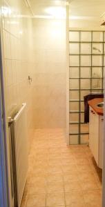 a bathroom with a shower and a tile floor at Studio Brinkstraat in Hoogeveen