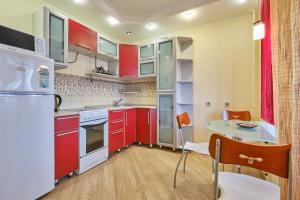una cocina con armarios rojos y una mesa. en ОК! Никитина, 20 №2, en Tomsk