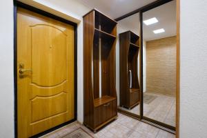 baño con puerta de madera y ducha a ras de suelo en ОК! Никитина, 20 №2, en Tomsk