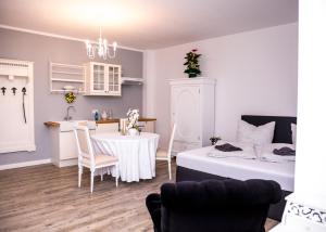 a room with a table and a kitchen and a bed at Boutique Hotel ma maison in Dömitz