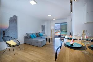 a living room with a couch and a table and chairs at Seametry Luxury Living Apartments, Adults Only, Excluding Ages 3 to 15 in Souda