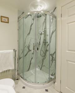 a bathroom with a shower with a glass door at Old Hall Hotel in Buxton