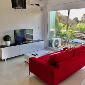 sala de estar con sofá rojo y TV en Hermoso loft vista panorámica en Buenos Aires