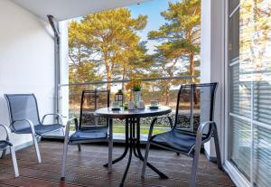 a table and chairs on a balcony with a window at Ostseeresidenz Gorki- Park - 02 mit Wellness und Schwimmbad in Bansin