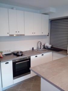 a kitchen with white cabinets and a sink at Cozy House Mētriņi in Ķekava +14 photos