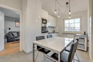 a kitchen and dining room with a table and chairs at Apartament Patio Mare by Grand Apartments in Sopot