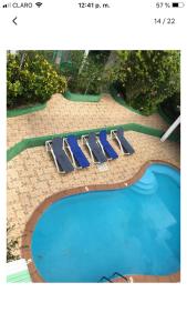 two lounge chairs sitting next to a swimming pool at Terrazas del Caribe, Boca Chica. in Boca Chica