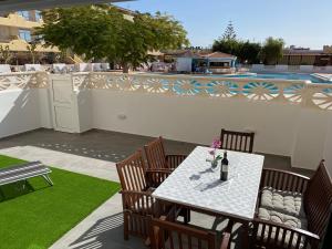 a patio with a table and chairs and a pool at Playa Paraiso apartment in Playa Paraiso