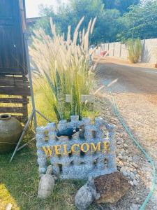 a welcome sign on the side of a road at Nong Or Blue House Resort in Sukhothai