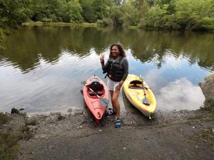 a woman standing next to two kayaks on a river at la casa de Carmen in Charlotte