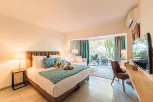a bedroom with a bed with a teddy bear on it at Hôtel Font Mourier in Cogolin
