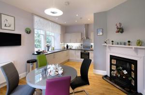 a kitchen and dining room with a table and a fireplace at East Lodge in Dyke