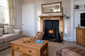 a living room with a fireplace and a couch and a table at East Lodge in Dyke