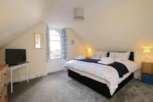 a bedroom with a large bed and a television at East Lodge in Dyke