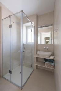 a bathroom with a glass shower and a sink at White Santa Maria Villa in Santa Maria