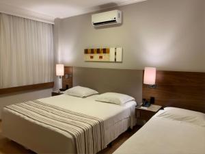Habitación de hotel con 2 camas y 2 lámparas en Bourbon Londrina Business Hotel, en Londrina