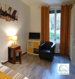 a living room with a chair and a television at Les Gîtes Havrais in Le Havre