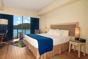 a hotel room with a bed and a balcony at Windward Passage Hotel in Charlotte Amalie