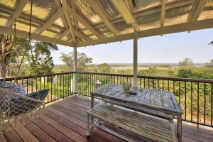 a wooden deck with a bench and a swing at Coastal Hideaway in South West Rocks