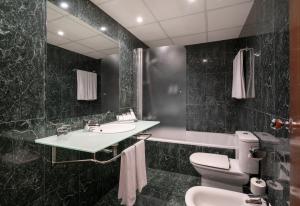 a bathroom with a sink and a toilet and a mirror at Berenguer IV in Tortosa