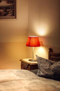 eine Lampe auf einem Tisch neben einem Bett in der Unterkunft Hotel und Restaurant Peking in Riesa