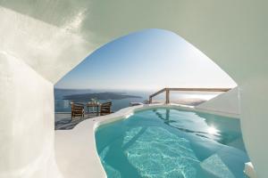 a pool in a house with a view of the ocean at Cocoon Suites in Imerovigli