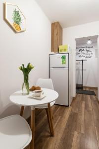 uma pequena cozinha com uma mesa e um frigorífico em Szmaragd em Rabka