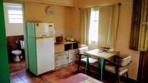 eine Küche mit einem weißen Kühlschrank und einem Tisch in der Unterkunft apartamento VINTAGE LU in Merlo