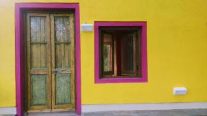 a yellow building with two doors and windows at apartamento VINTAGE LU in Merlo +19 photos