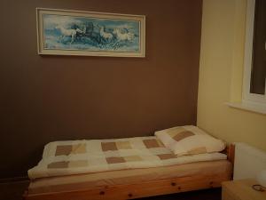 a bed in a room with a painting on the wall at Gospodarstwo Agroturystyczne Anielin in Okonek