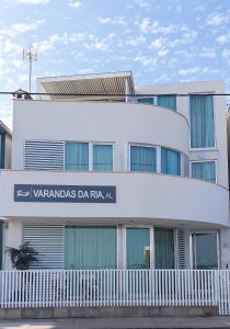 een wit gebouw met een bord ervoor bij Varandas da Ria in Costa Nova